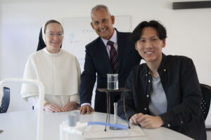 HSc student and chemistry teacher with science equipment.